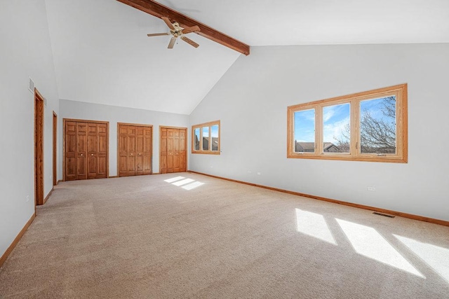 unfurnished bedroom featuring visible vents, multiple closets, high vaulted ceiling, beamed ceiling, and baseboards