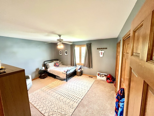 carpeted bedroom with a ceiling fan and baseboards