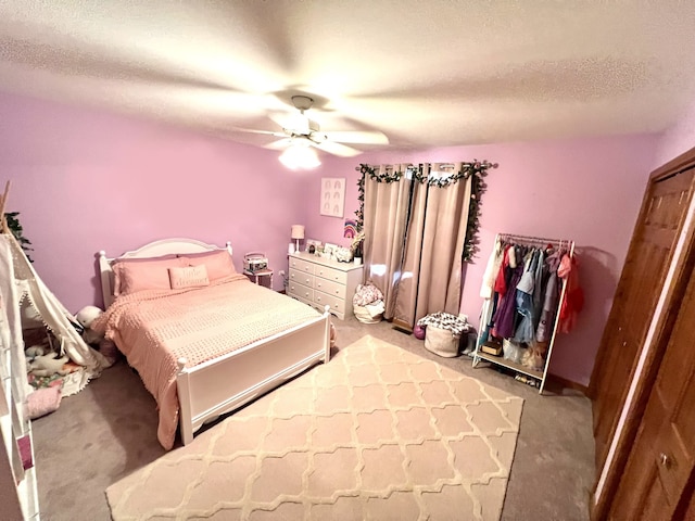 carpeted bedroom featuring a textured ceiling and a ceiling fan