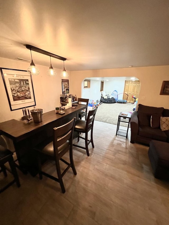 dining room featuring arched walkways and wood finished floors