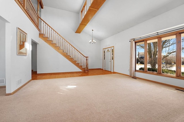 unfurnished living room with a notable chandelier, visible vents, stairway, and carpet floors