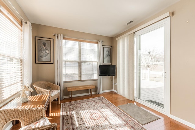 sitting room featuring wood finished floors, visible vents, and baseboards