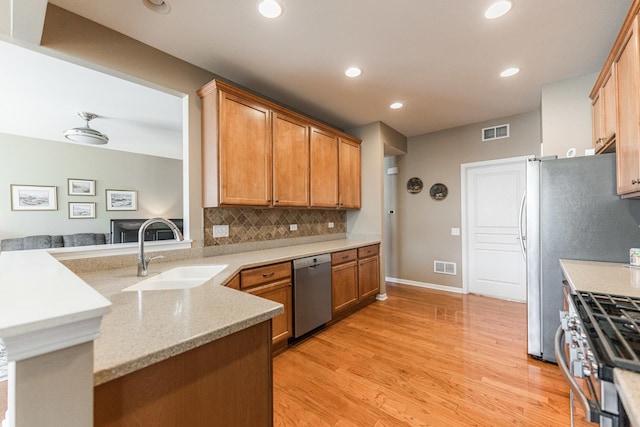 kitchen featuring decorative backsplash, visible vents, appliances with stainless steel finishes, and a sink