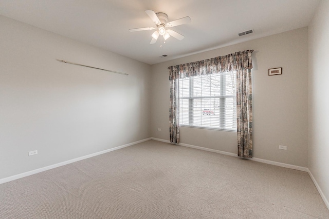 unfurnished room with visible vents, baseboards, light colored carpet, and ceiling fan