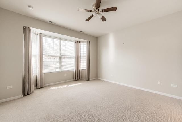 empty room with light carpet, visible vents, and baseboards