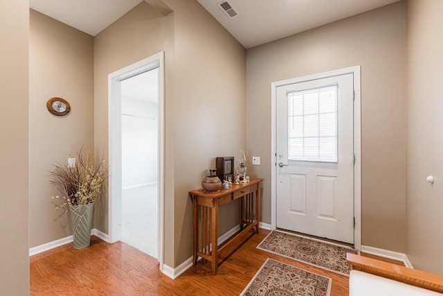 doorway featuring wood finished floors, visible vents, and baseboards