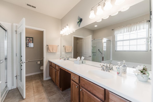 full bathroom featuring visible vents, toilet, double vanity, a stall shower, and a sink