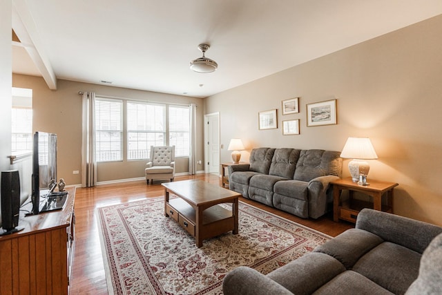 living area featuring visible vents, wood finished floors, and baseboards