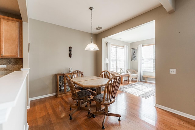 dining area featuring visible vents, baseboards, and light wood-style flooring