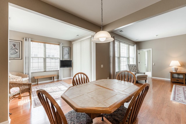 dining room with a wealth of natural light, visible vents, light wood-style flooring, and baseboards