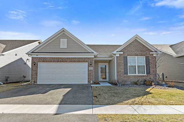 view of front facade with aphalt driveway, brick siding, a garage, and a front yard