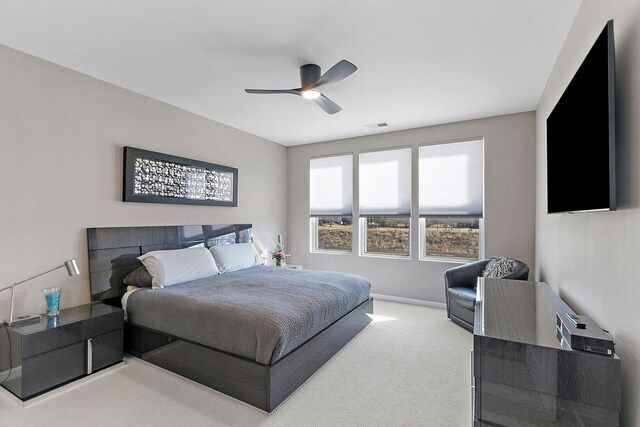 bedroom with visible vents, light carpet, baseboards, and a ceiling fan