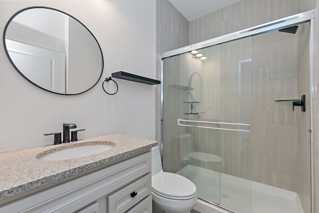 full bathroom featuring toilet, a stall shower, and vanity