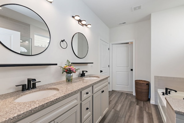 full bathroom featuring a sink, visible vents, and wood finished floors