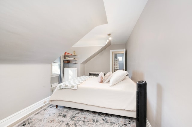 bedroom featuring vaulted ceiling, wood finished floors, and baseboards