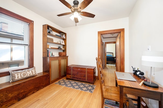 office with light wood finished floors and ceiling fan