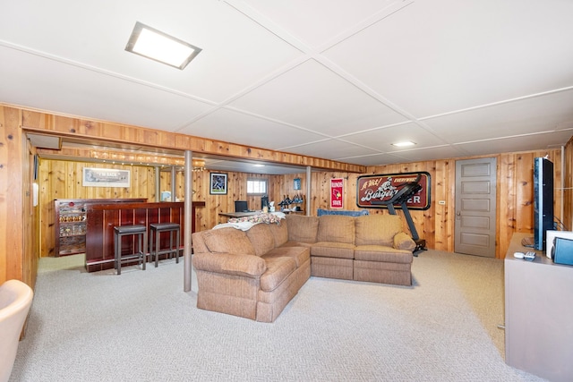 carpeted living room featuring a bar and wood walls