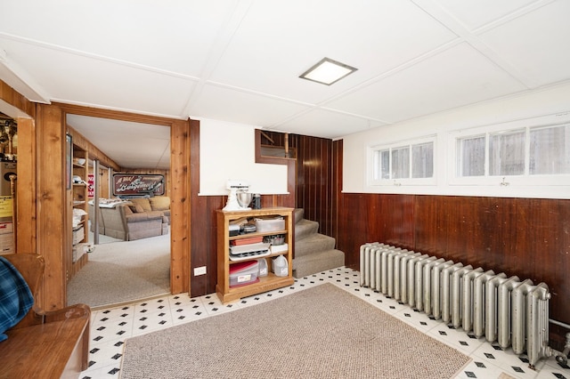 interior space with tile patterned floors, stairway, radiator, and wood walls