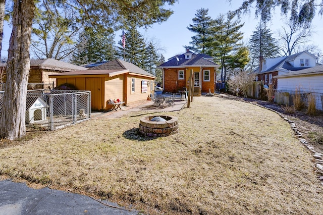 exterior space with an outdoor fire pit, an outdoor structure, and fence