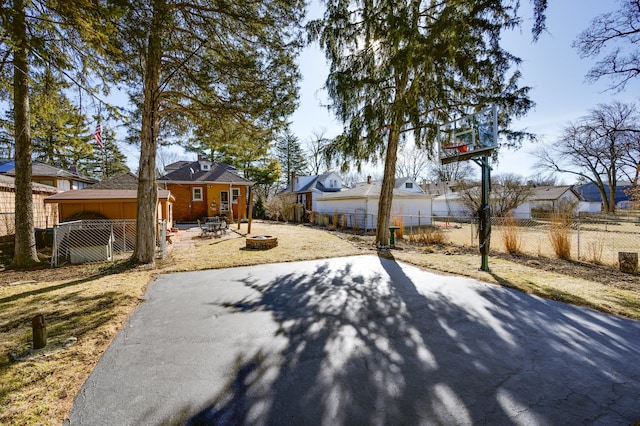 exterior space featuring a patio area, fence, a residential view, and an outdoor fire pit