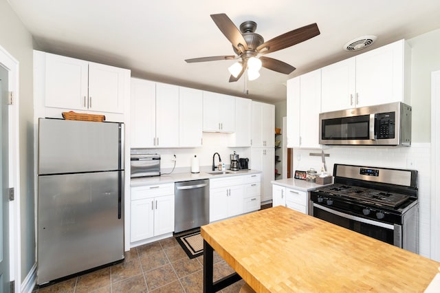 kitchen featuring visible vents, tasteful backsplash, appliances with stainless steel finishes, and white cabinets