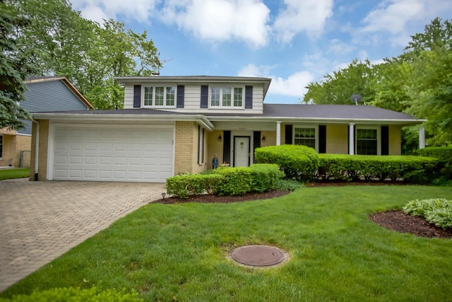 view of front of house with a front lawn, decorative driveway, and brick siding