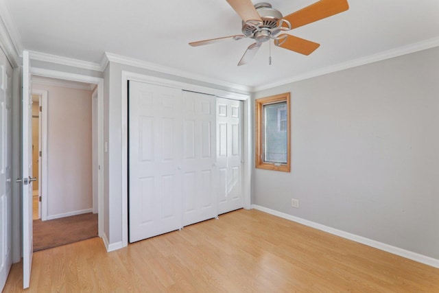 unfurnished bedroom featuring baseboards, light wood finished floors, ceiling fan, ornamental molding, and a closet