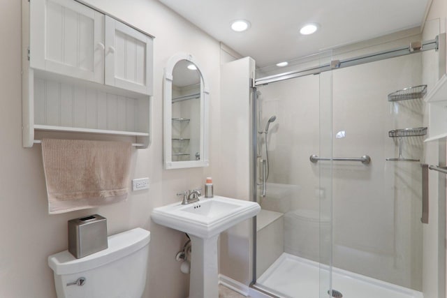 full bathroom with recessed lighting, a stall shower, toilet, and a sink