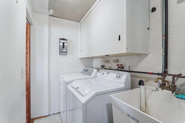 laundry room featuring washer and clothes dryer, cabinet space, and a sink