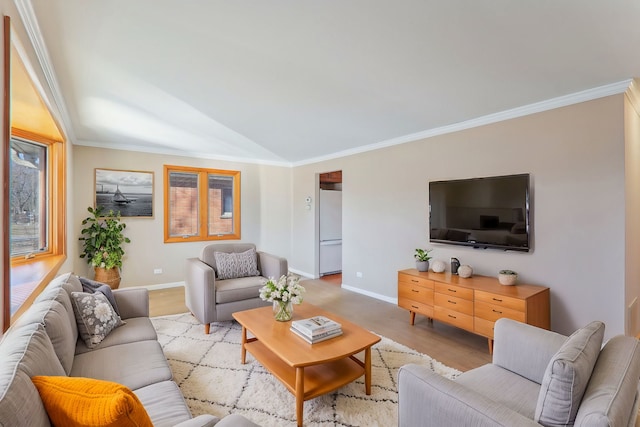 living area with baseboards, ornamental molding, and light wood finished floors