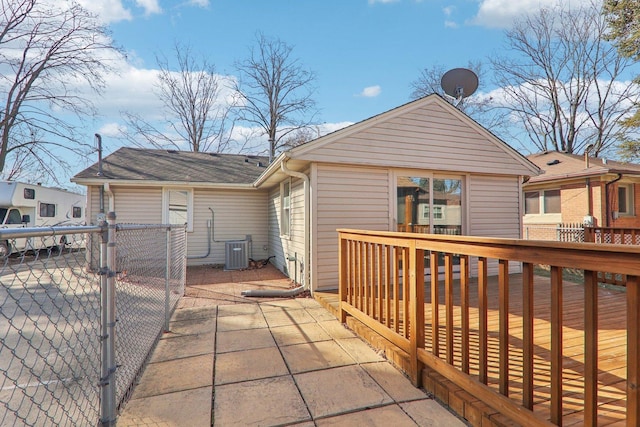 rear view of property with central AC unit, fence, and a wooden deck