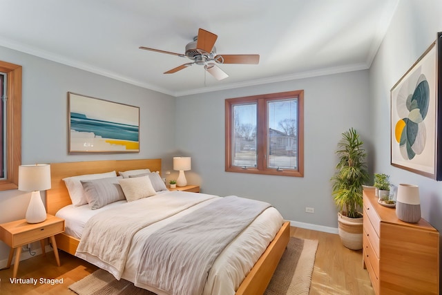 bedroom with a ceiling fan, crown molding, baseboards, and wood finished floors