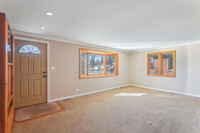 foyer entrance with visible vents, baseboards, carpet floors, and ornamental molding