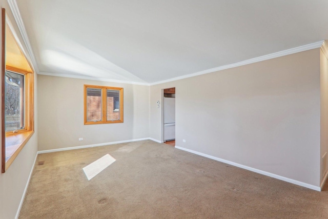 empty room featuring baseboards, light colored carpet, crown molding, and vaulted ceiling