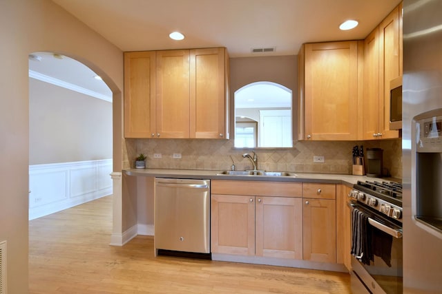 kitchen with visible vents, a wainscoted wall, light countertops, appliances with stainless steel finishes, and a sink