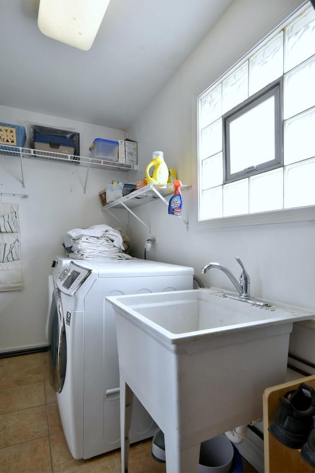 clothes washing area with laundry area, light tile patterned flooring, separate washer and dryer, and a sink