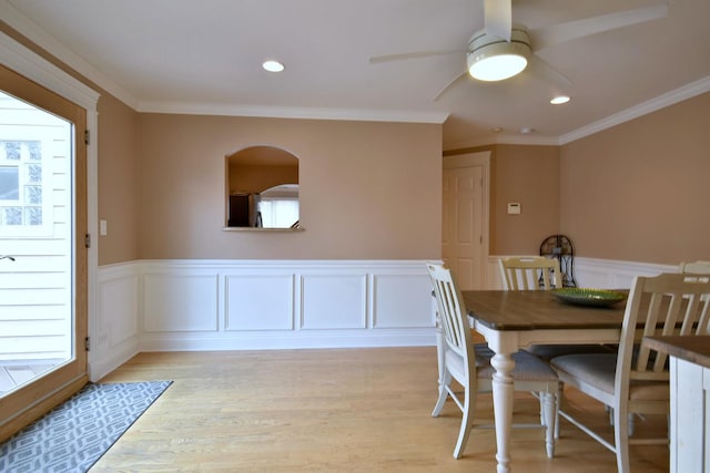 dining space featuring ceiling fan, light wood-type flooring, and ornamental molding