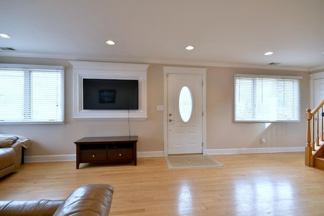 entrance foyer with stairs, plenty of natural light, visible vents, and ornamental molding