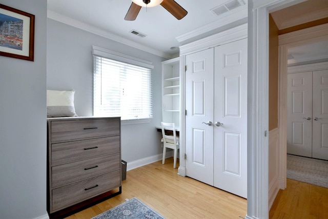 bedroom featuring crown molding, light wood-style floors, visible vents, and a closet