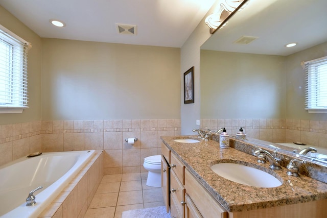 bathroom with tile patterned floors, a bath, visible vents, and a sink