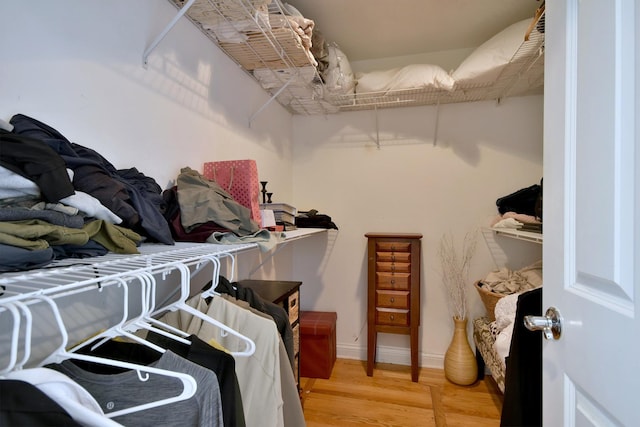 walk in closet with light wood-style flooring