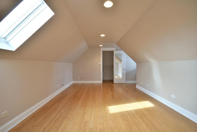 bonus room featuring recessed lighting, vaulted ceiling with skylight, light wood-type flooring, and baseboards