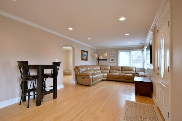 living room with recessed lighting, light wood-type flooring, arched walkways, and ornamental molding