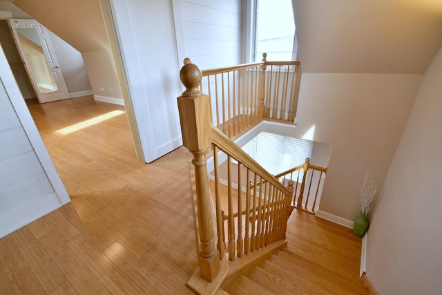 stairs with vaulted ceiling, baseboards, and wood finished floors