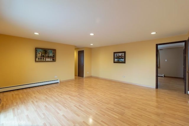 spare room featuring light wood-style floors, recessed lighting, baseboards, and a baseboard radiator