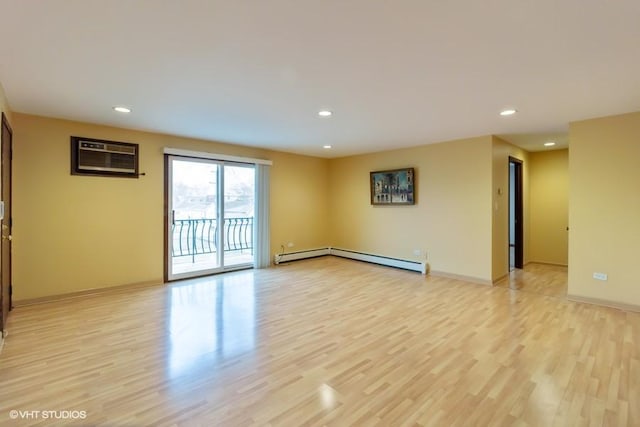 empty room featuring recessed lighting, a baseboard radiator, and light wood-style floors