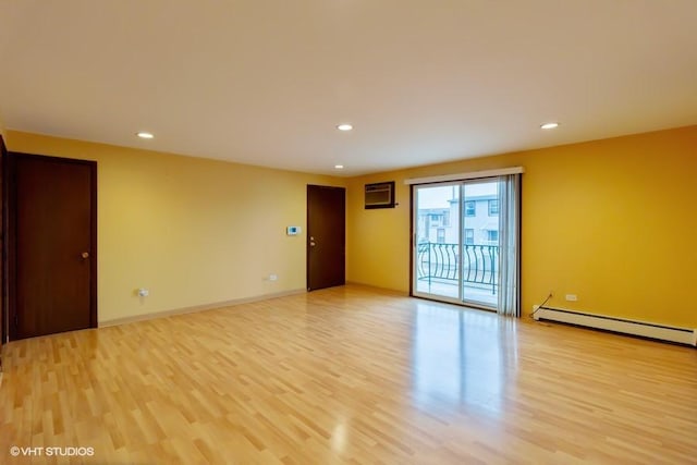 spare room with recessed lighting, a baseboard heating unit, baseboards, light wood-style floors, and a wall mounted AC