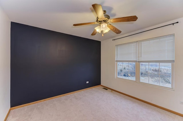 unfurnished room featuring visible vents, baseboards, a ceiling fan, and light colored carpet