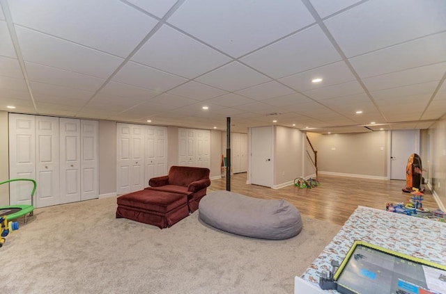 living room with recessed lighting, a paneled ceiling, stairway, wood finished floors, and baseboards