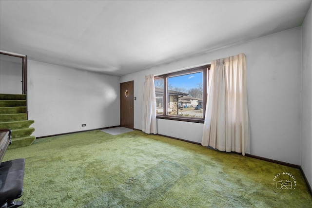 carpeted empty room with stairs and baseboards